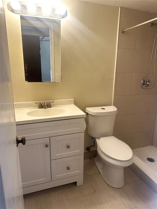 bathroom featuring toilet, a shower stall, and vanity