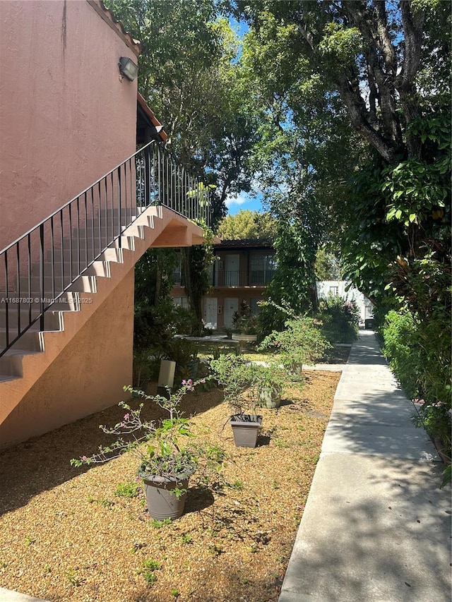 view of side of home featuring stairs and stucco siding