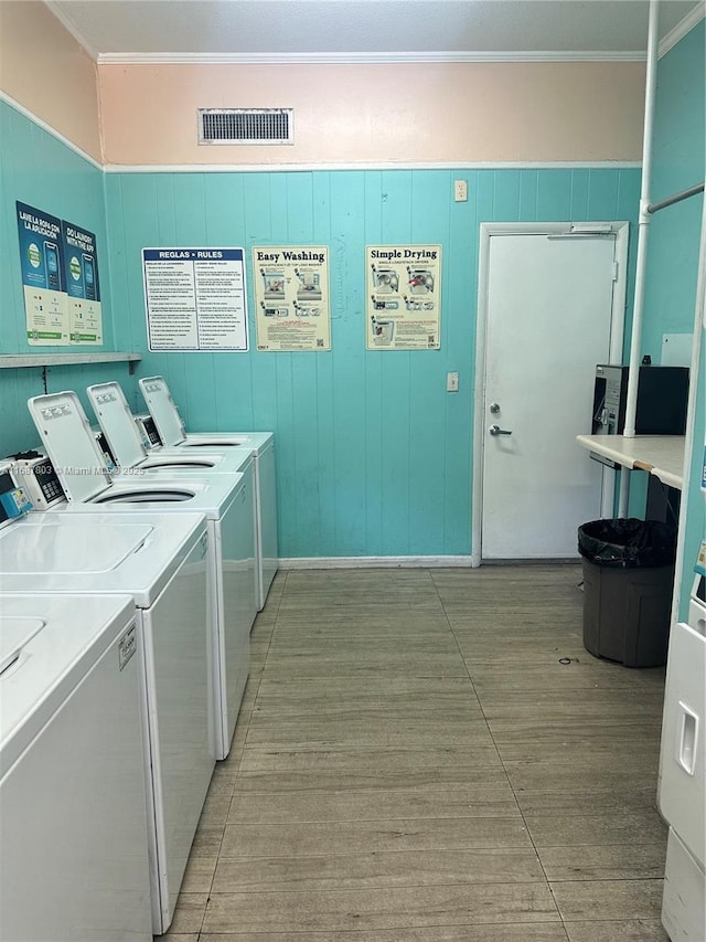 common laundry area with ornamental molding, visible vents, and independent washer and dryer