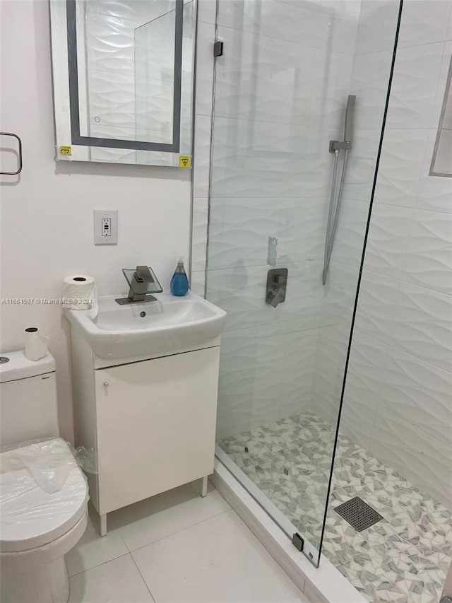 bathroom with walk in shower, vanity, tile patterned floors, and toilet