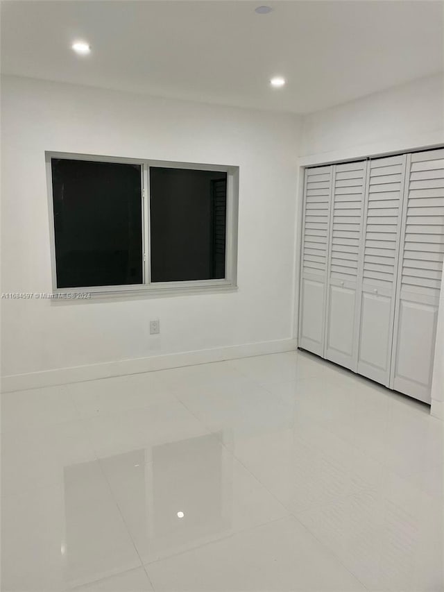 1201 Marseille Dr Unit 17, Miami Beach, FL 33141 - unfurnished bedroom featuring light tile patterned floors, recessed lighting, baseboards, and a closet
