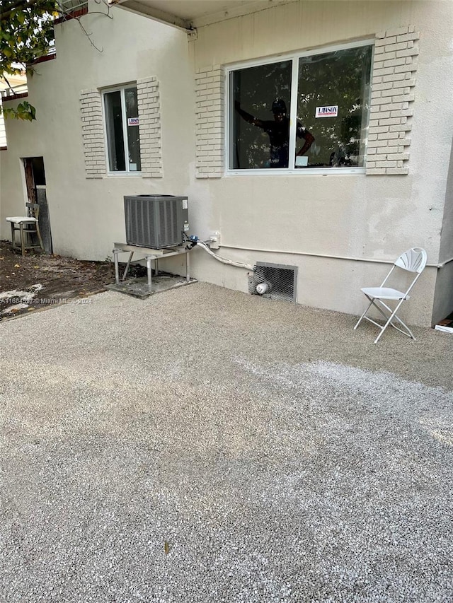 view of side of property with central air condition unit and a patio area