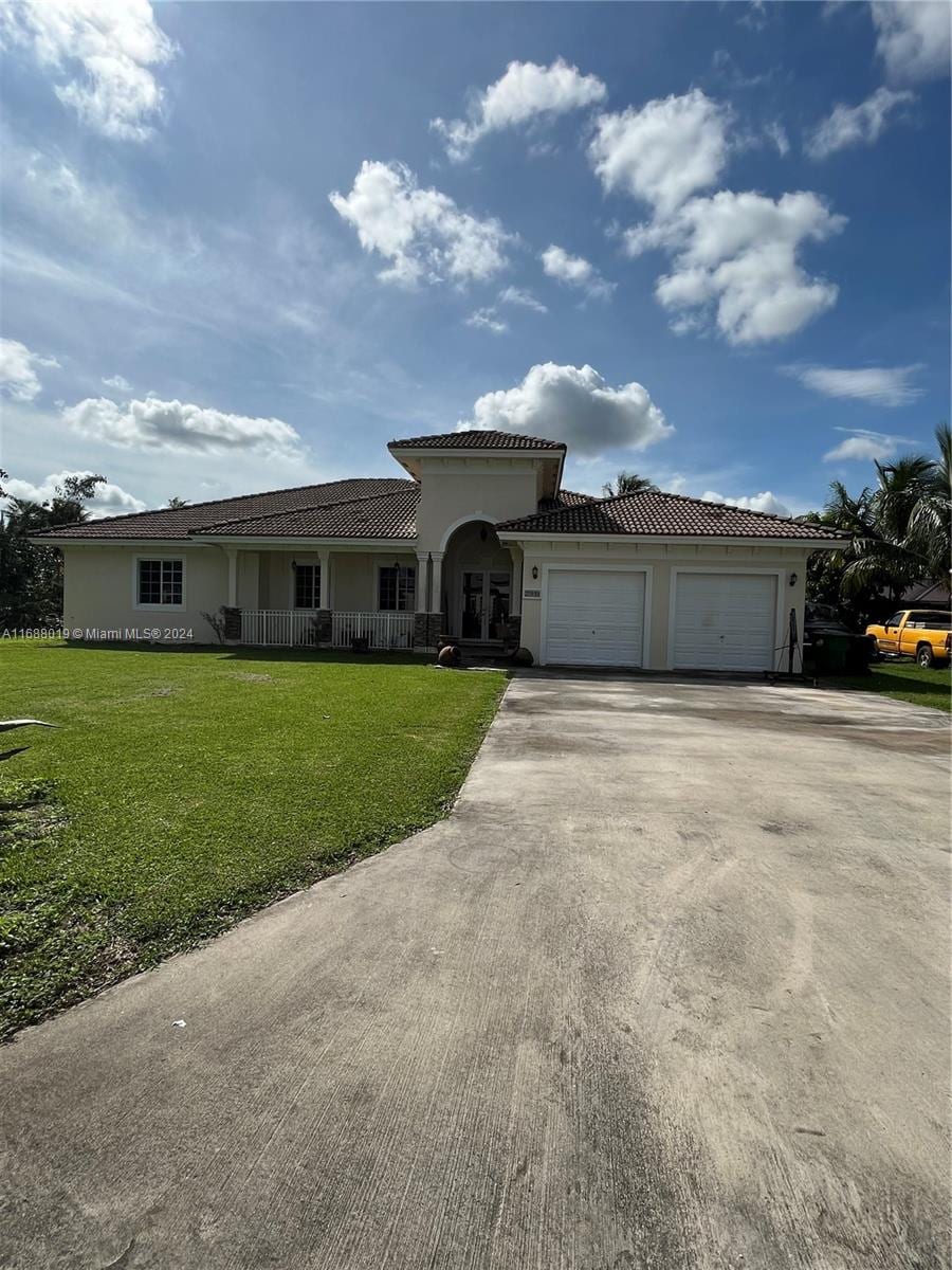20494 SW 325th St, Homestead, FL 33030 - view of front facade with a garage and a front yard