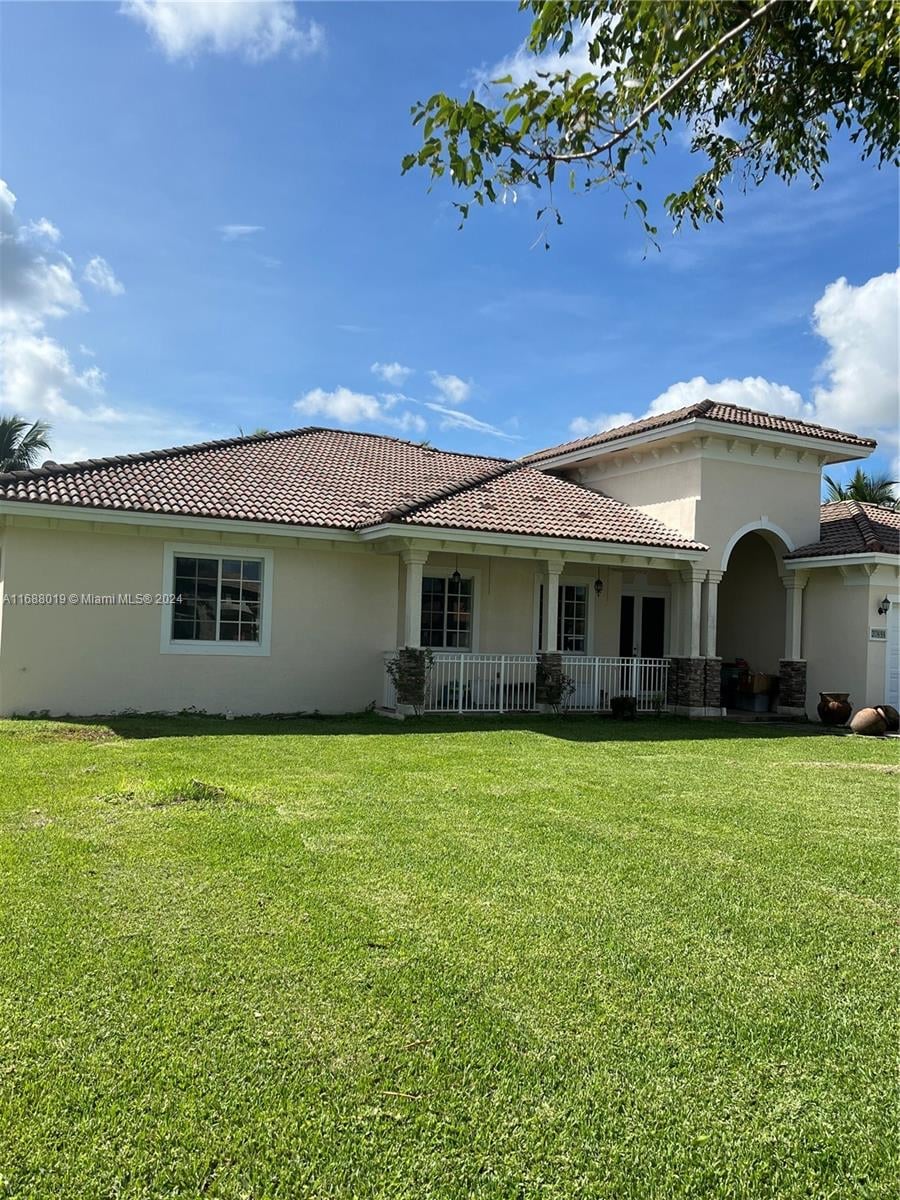 20494 SW 325th St, Homestead, FL 33030 - rear view of property with a lawn and a garage