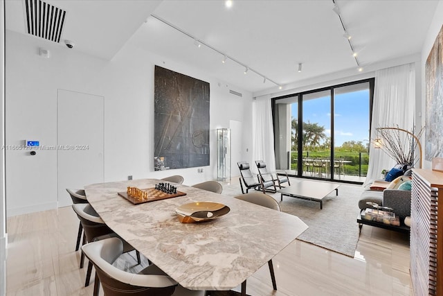 dining room featuring light wood-type flooring and rail lighting