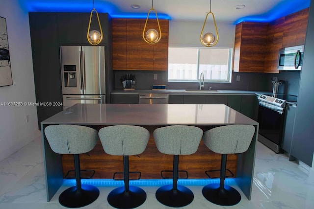 kitchen featuring appliances with stainless steel finishes, sink, a kitchen breakfast bar, and a center island