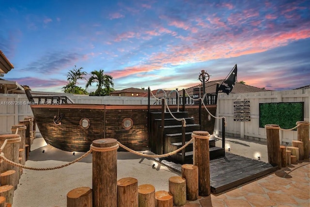 patio terrace at dusk featuring a playground