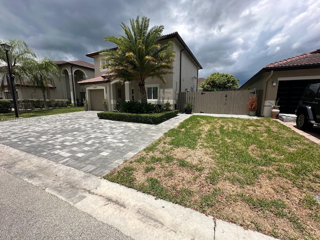 mediterranean / spanish home with a garage and a front yard