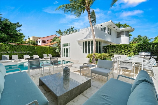 back of property with outdoor lounge area, a fenced in pool, and a patio area