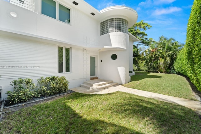 view of exterior entry with a yard