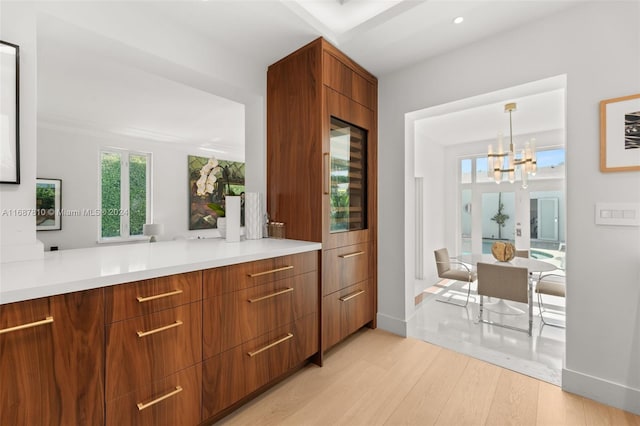 kitchen featuring light wood-type flooring, hanging light fixtures, and a notable chandelier