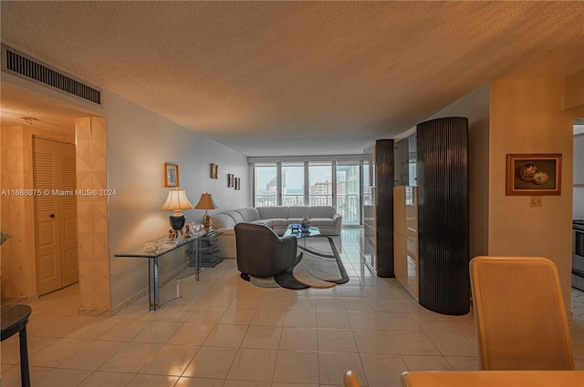 tiled living room featuring a textured ceiling