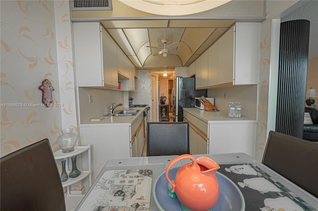 kitchen featuring white cabinetry, sink, and ceiling fan