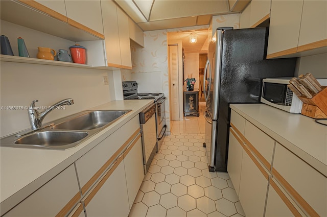 kitchen featuring light tile patterned floors, white cabinetry, sink, and appliances with stainless steel finishes