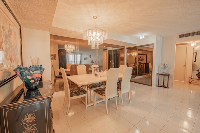 tiled dining space with an inviting chandelier and a textured ceiling