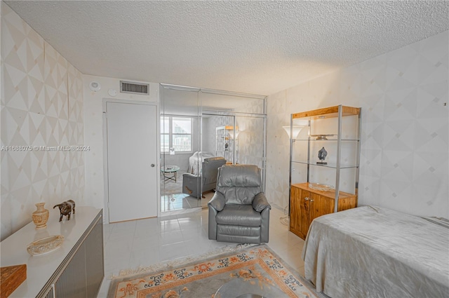 tiled bedroom featuring tile walls, a textured ceiling, and a closet