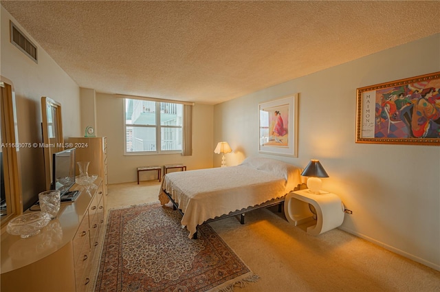 bedroom with carpet and a textured ceiling