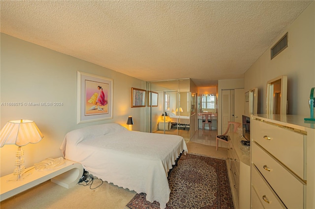 carpeted bedroom featuring a textured ceiling and a closet