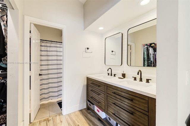 bathroom with hardwood / wood-style floors, vanity, and curtained shower