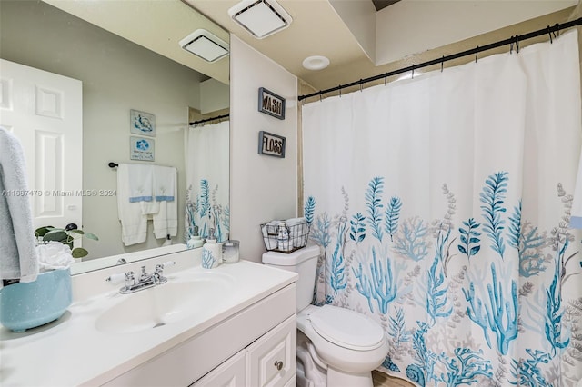 bathroom with walk in shower, vanity, and toilet