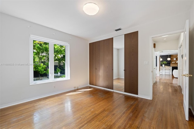 unfurnished bedroom with a closet and wood-type flooring