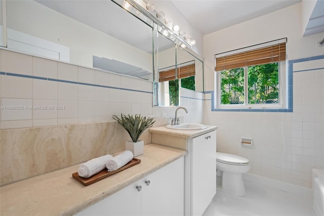 bathroom with tile patterned floors, vanity, toilet, and tile walls