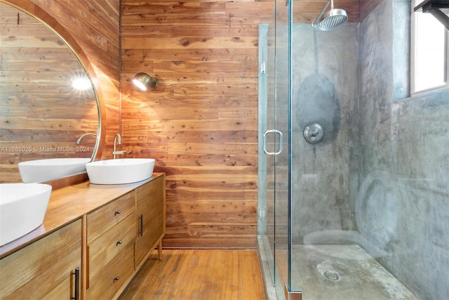 bathroom with a shower with door, wood walls, vanity, and wood-type flooring