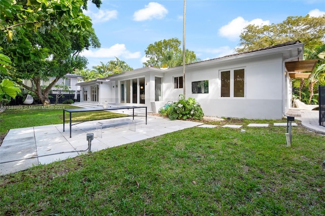 back of property with a patio area and a yard