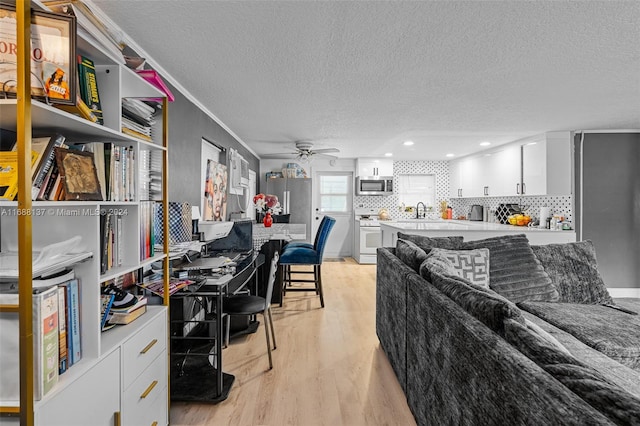 office with sink, ceiling fan, a textured ceiling, and light hardwood / wood-style floors