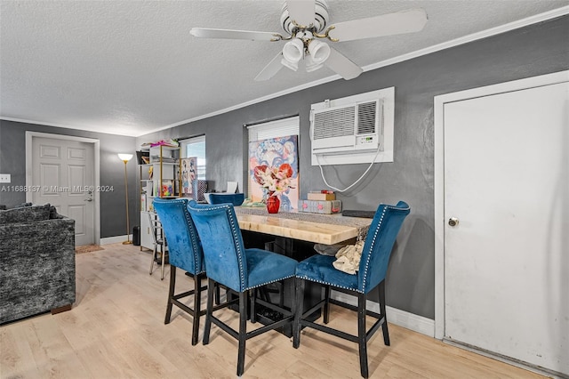 dining area with a wall mounted AC, light hardwood / wood-style floors, a textured ceiling, and crown molding