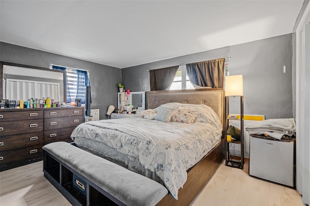 bedroom with refrigerator and light hardwood / wood-style flooring