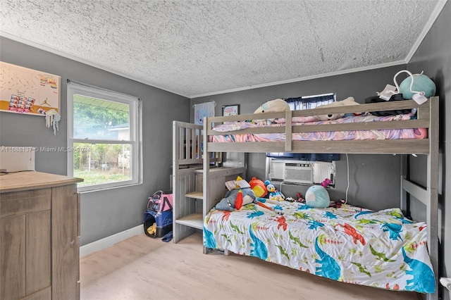 bedroom featuring cooling unit, hardwood / wood-style floors, crown molding, and a textured ceiling