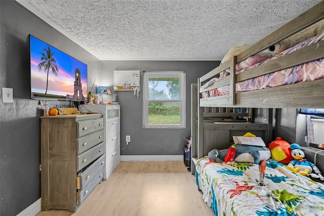 bedroom featuring light hardwood / wood-style floors and a textured ceiling