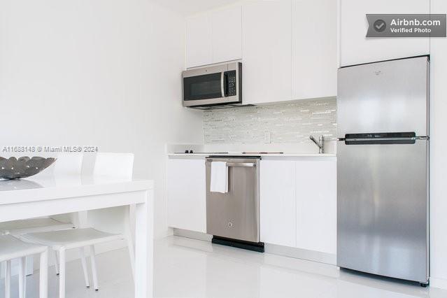 kitchen with white cabinetry, appliances with stainless steel finishes, and tasteful backsplash