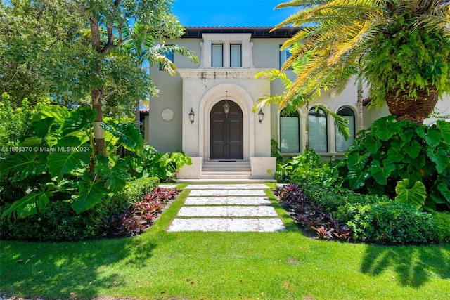 property entrance featuring a lawn