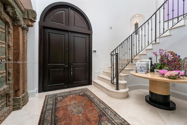 tiled foyer with a towering ceiling