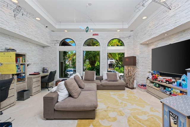 living room with a high ceiling, light tile patterned floors, crown molding, and a tray ceiling