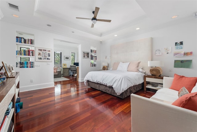 bedroom with ornamental molding, dark wood-type flooring, ceiling fan, and a raised ceiling