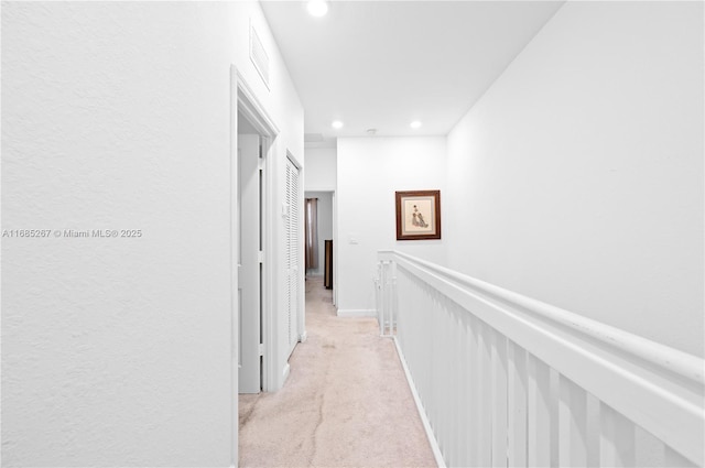 hall featuring light colored carpet