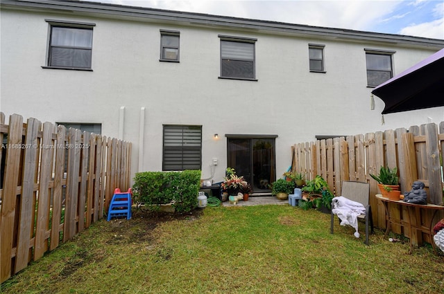 back of house with a lawn