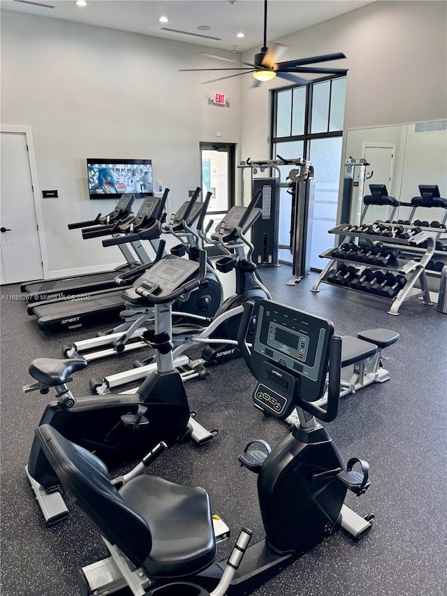 gym featuring ceiling fan and a towering ceiling