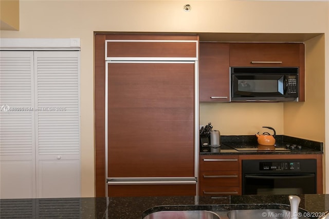 kitchen with dark stone countertops and black appliances