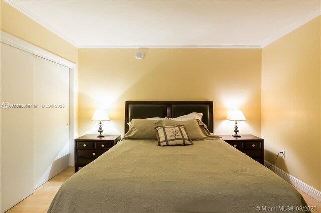 bedroom with crown molding and light hardwood / wood-style flooring