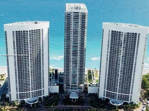 view of building exterior featuring a water view and central AC unit