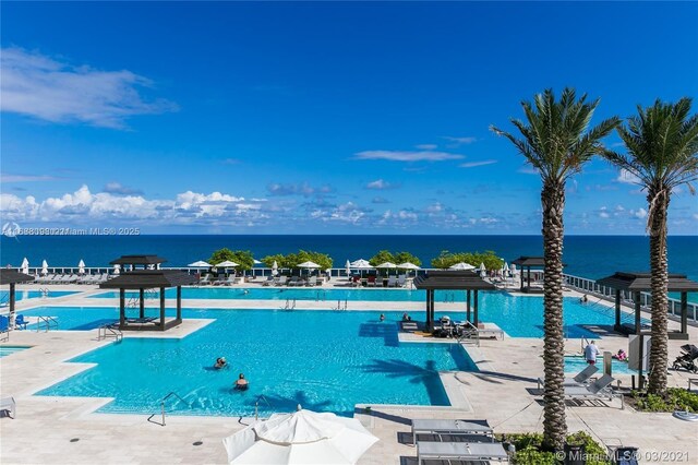 view of pool with a patio and a water view