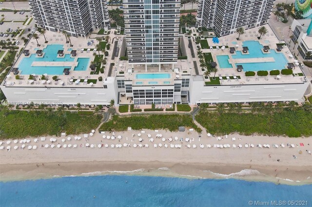 birds eye view of property featuring a beach view and a water view