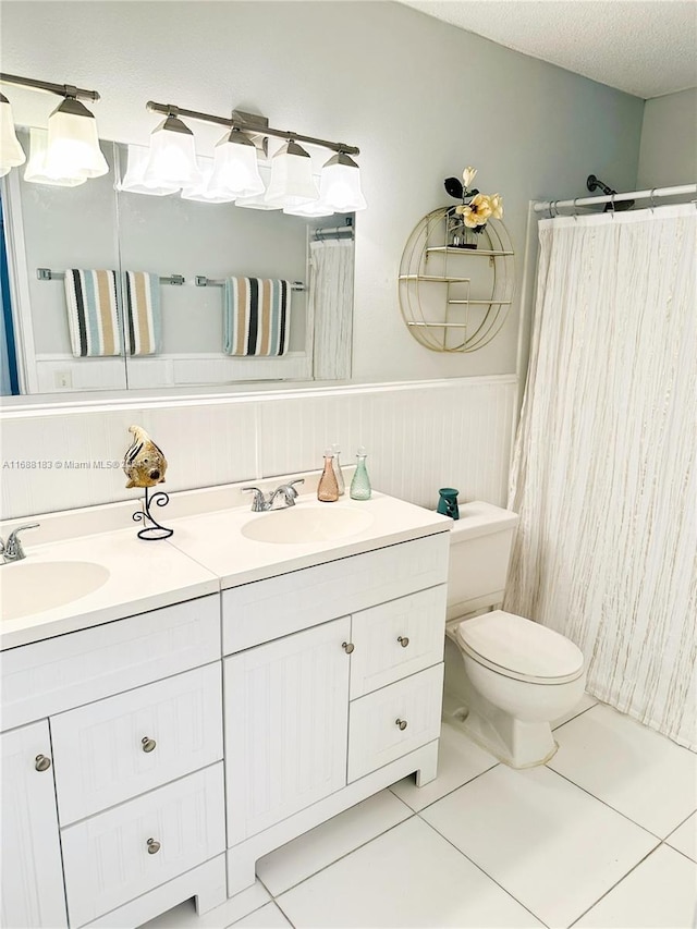 bathroom featuring tile patterned floors, vanity, a textured ceiling, and toilet