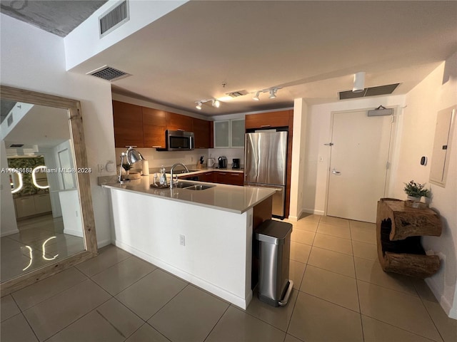 kitchen featuring electric panel, stainless steel appliances, sink, tile patterned flooring, and kitchen peninsula