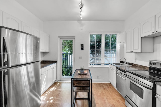 kitchen with white cabinets, light hardwood / wood-style floors, and stainless steel appliances