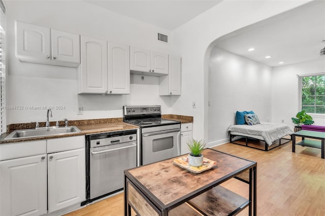 kitchen featuring white cabinetry, sink, stainless steel appliances, and light wood-type flooring